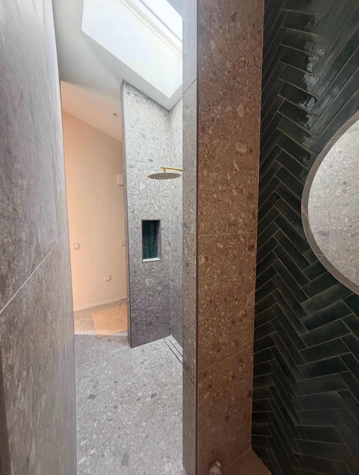 Douche ouverte en carrelage minéral gris avec faïence sombre posée en chevrons