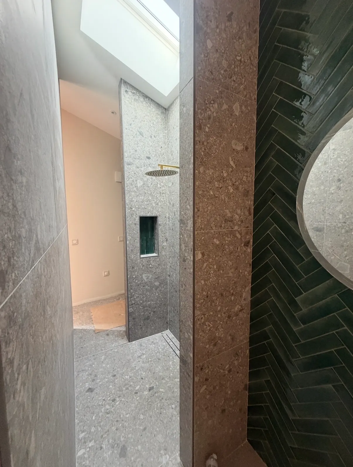 Douche ouverte en carrelage minéral gris avec faïence sombre posée en chevrons