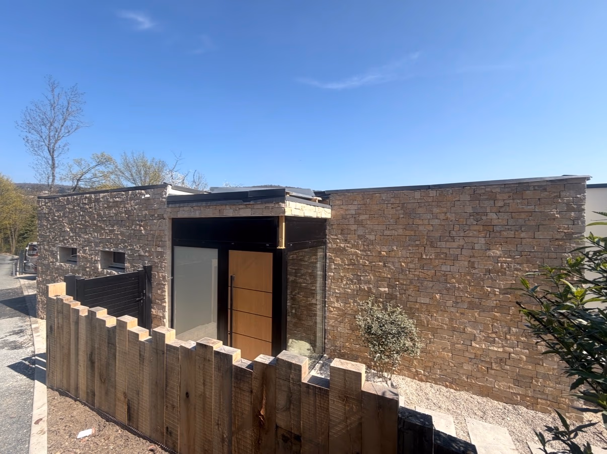 Maison contemporaine dont les murs extérieurs sont habillés de parement en pierre naturelle