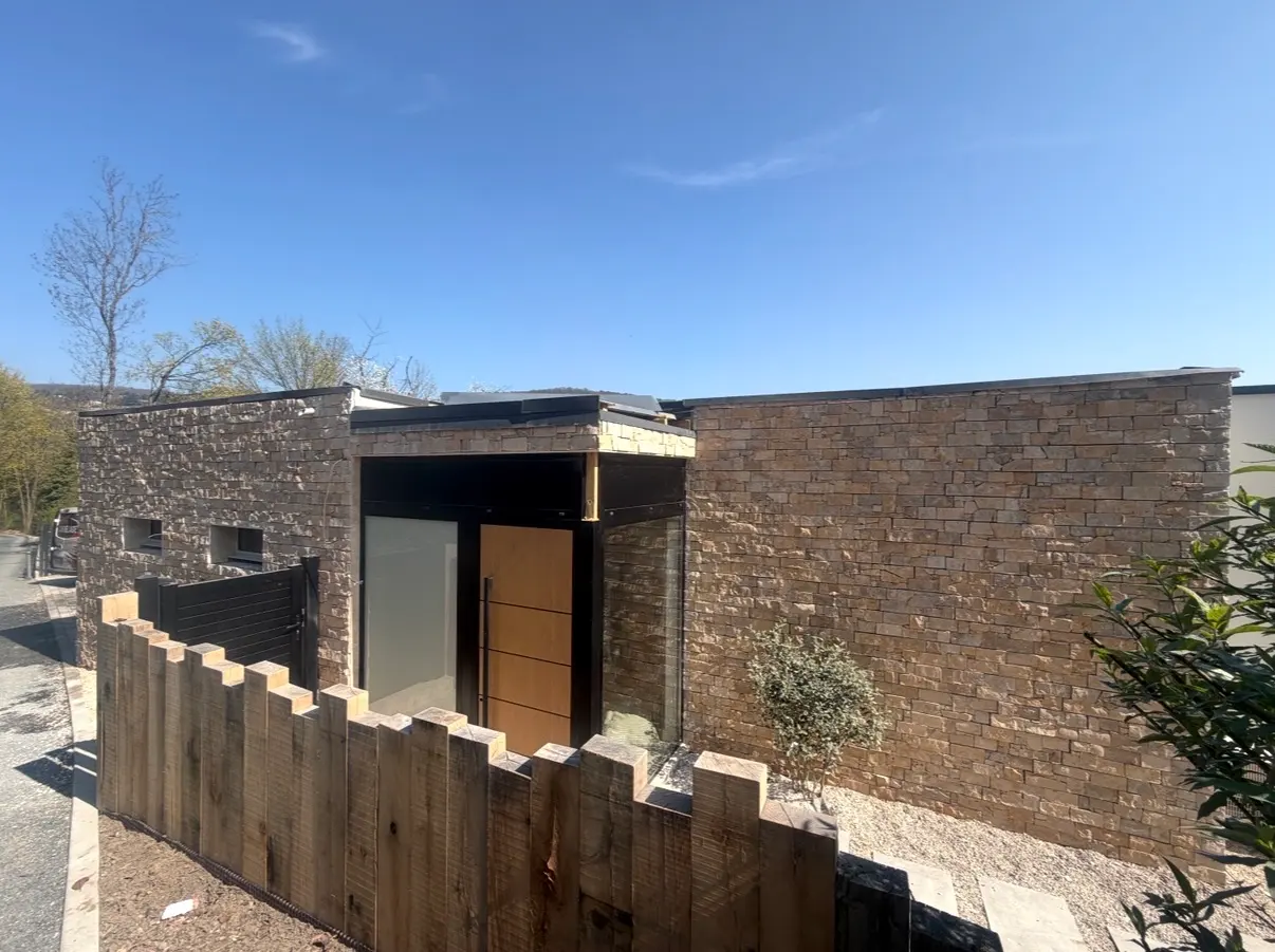 Maison contemporaine dont les murs extérieurs sont habillés de parement en pierre naturelle