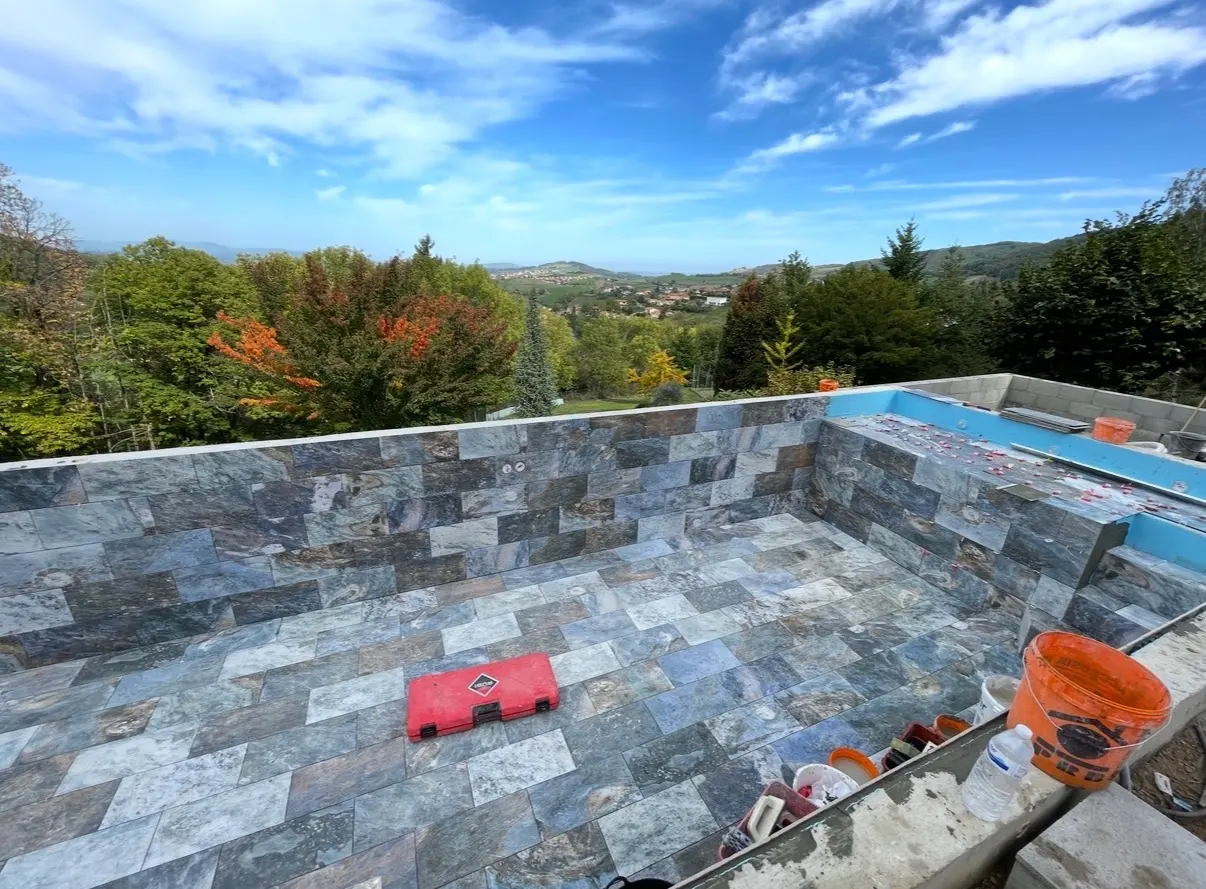 Piscine en cours de finition habillée de carreaux en pierre naturelle gris bleuté