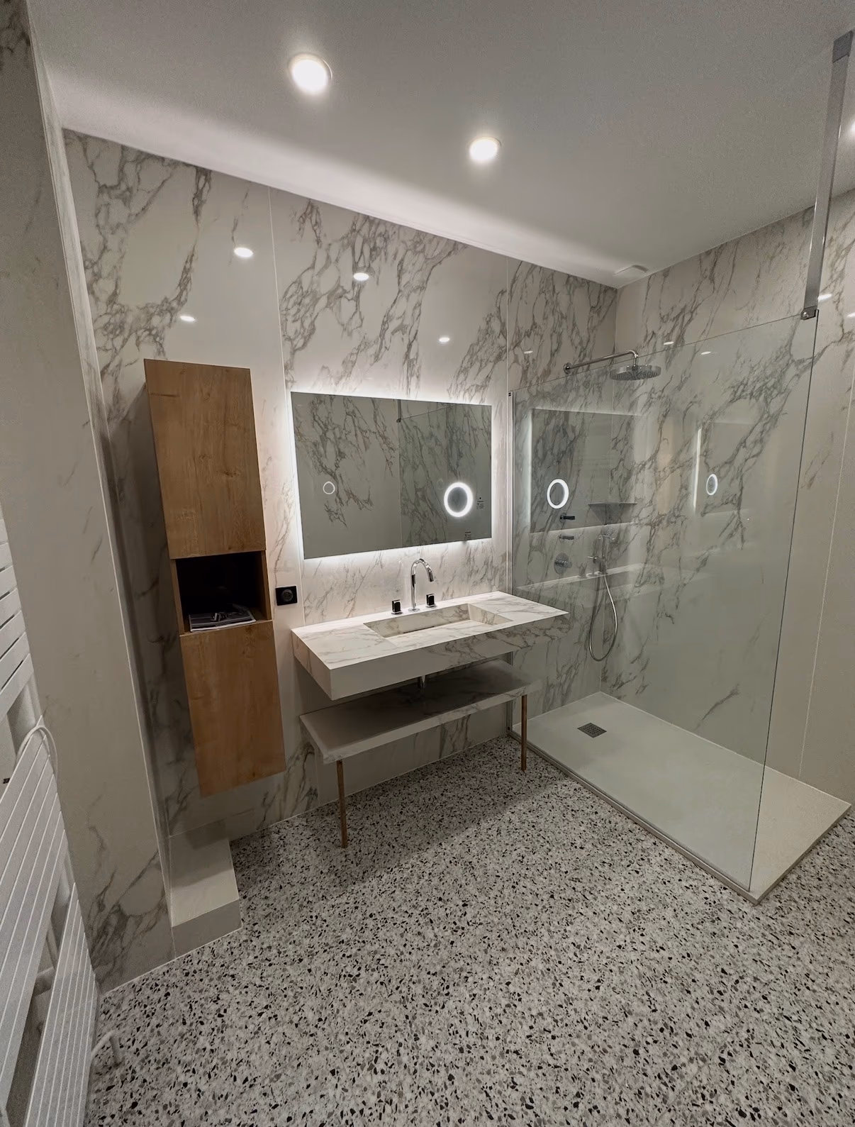Salle de bain avec grands carreaux effet marbre aux murs et sol terrazzo