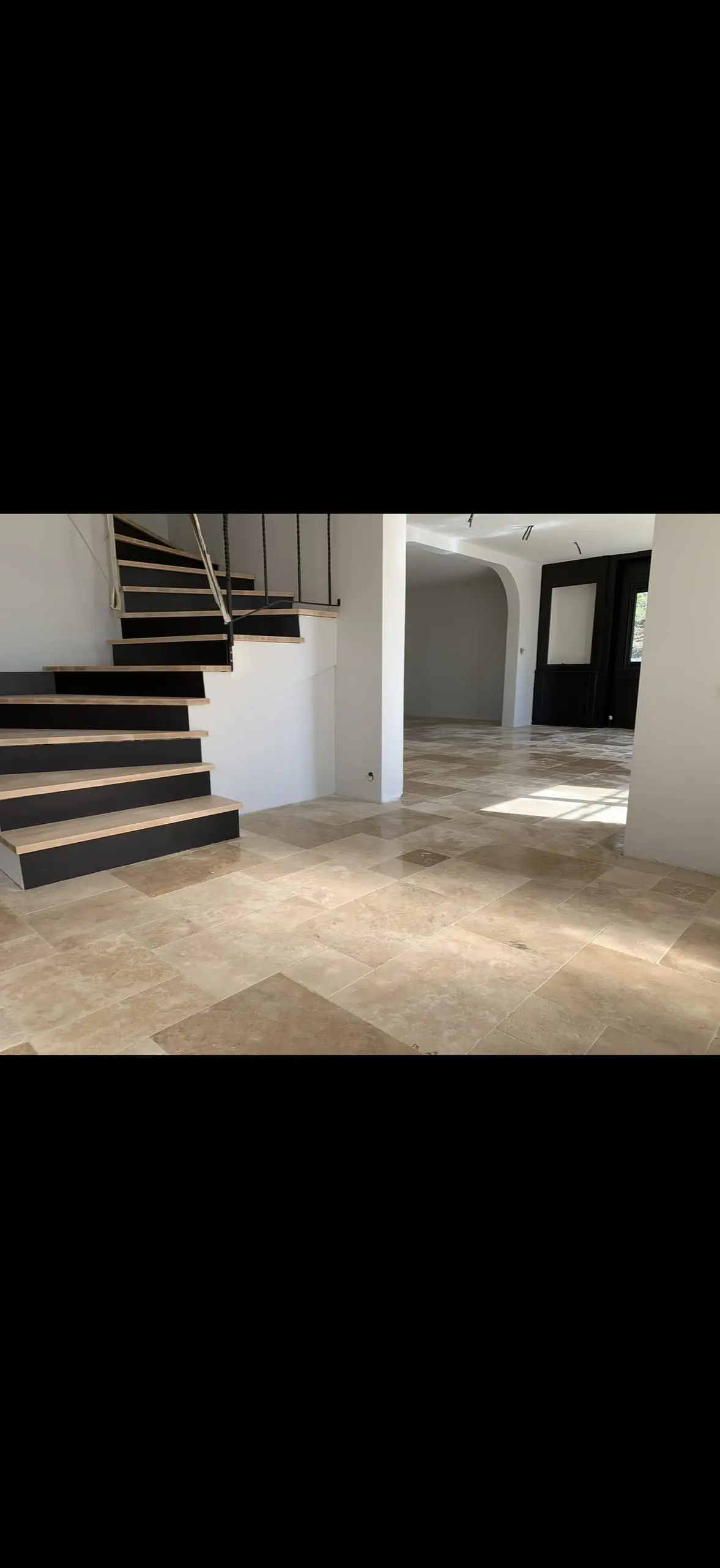 Sol en travertin beige dans une pièce ouverte avec escalier contemporain